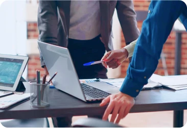 Pessoas apontando para a tela do notebook.